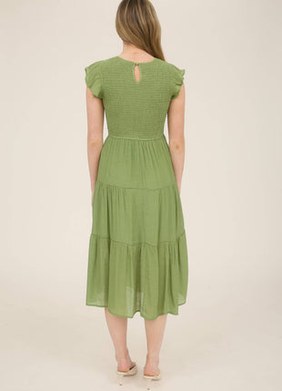 Woman wearing a green dress on a beige background