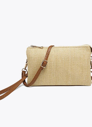 Beige woven handbag with brown leather strap on a white background