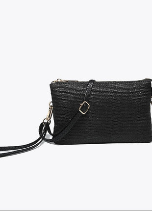 A black textured crossbody clutch bag with a matching wristlet strap and gold-tone hardware, displayed against a clean white background.