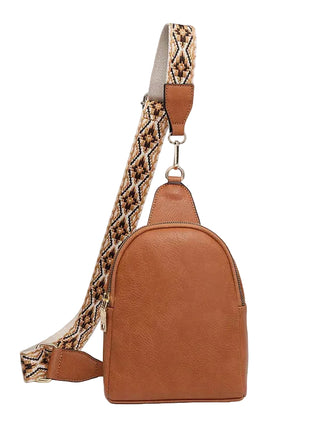 Brown leather backpack with a patterned strap on a white background