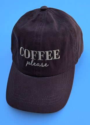 A dark brown cotton baseball cap with 'COFFEE please' embroidered on the front, set against a solid blue background.