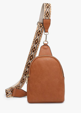 Brown leather backpack with a patterned strap on a white background