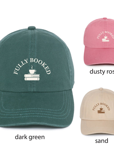 Three baseball caps shown on a white background with color labels: a large dark green cap labeled 'dark green,' a smaller dusty rose cap labeled 'dusty rose,' and a smaller sand cap labeled 'sand.' Each cap has white embroidered text reading 'FULLY BOOKED' above a small coffee cup and books graphic.