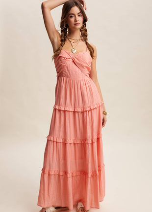 Woman wearing a coral pink dress with layered skirt on a beige background
