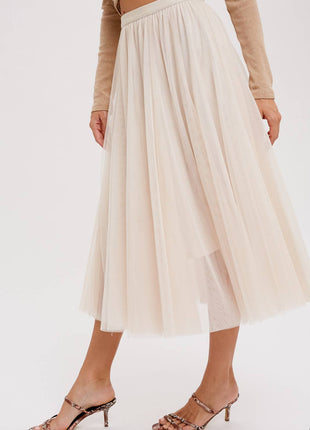 Person wearing a beige skirt and high-heeled sandals on a white background