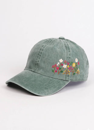 Green cap with floral embroidery on a white background