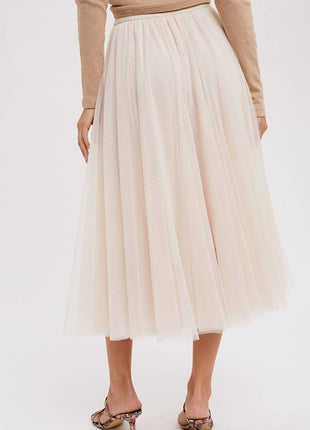 Person wearing a beige tulle skirt on a white background