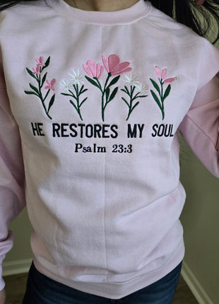 White hoodie with floral design and text on a person wearing it.