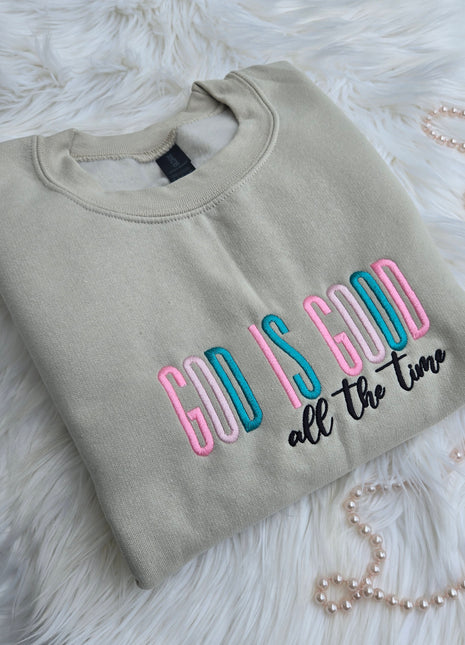 Folded gray sweatshirt with colorful text on a fluffy white surface