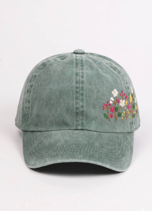 Green baseball cap with floral embroidery on a white background