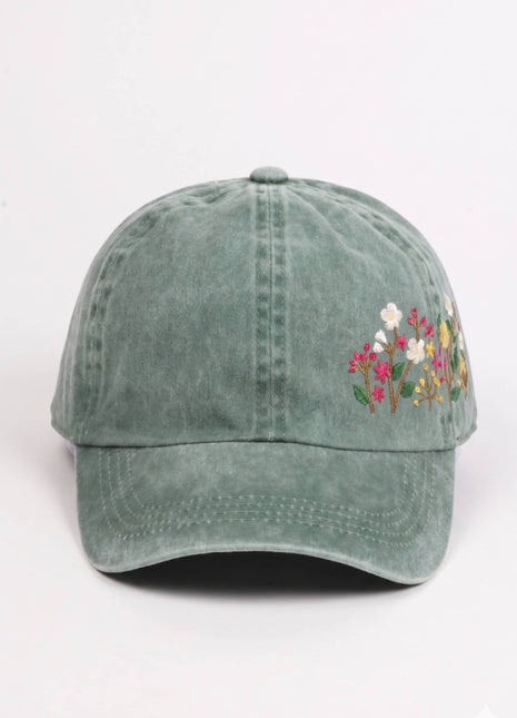 Green baseball cap with floral embroidery on a white background