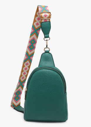 Green leather sling bag with a colorful patterned strap on a white background