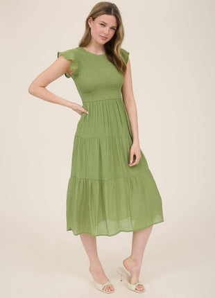 Woman wearing a green dress on a beige background
