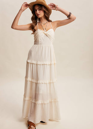 Woman wearing a white dress and straw hat against a plain background