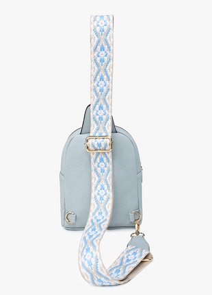 Light blue crossbody bag with a patterned strap on a white background