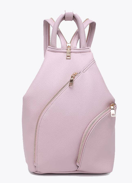 A light pink pebbled faux-leather backpack with gold-tone hardware, featuring dual shoulder straps, a diagonal zippered pocket, and a top zip closure, shown against a plain white background.