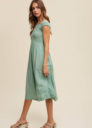 Woman wearing a light green dress against a beige background