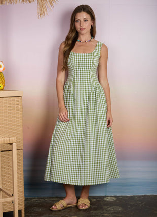 Woman wearing a green checkered dress standing against a blurred background