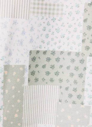 Patchwork quilt with floral, polka dot, and striped patterns in soft colors.