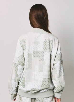 Person wearing a light green textured outfit on a plain background