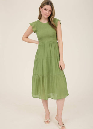 Woman wearing a green dress on a plain background