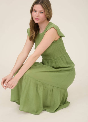 Woman wearing a green dress sitting on a white background