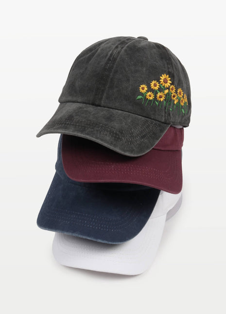 Stack of three baseball caps with floral embroidery on a white background