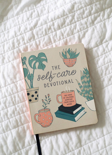 Book titled 'The Self-Care Devotional' on a white textured surface