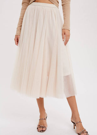 Person wearing a beige pleated skirt and brown top on a white background