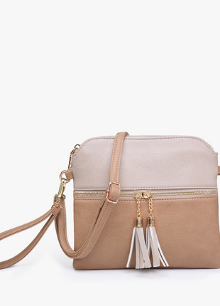 Two-tone handbag with tassel details on a white background
