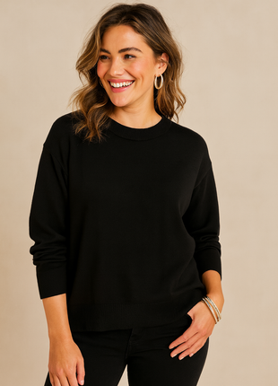Woman wearing a black sweater against a beige background