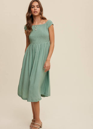 Woman wearing a green dress against a beige background