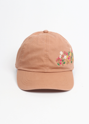 Caramel-colored cap with floral embroidery on a white background