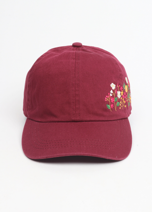 Maroon cap with floral embroidery on a white background