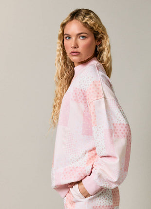 Woman wearing a pink checkered outfit against a plain background